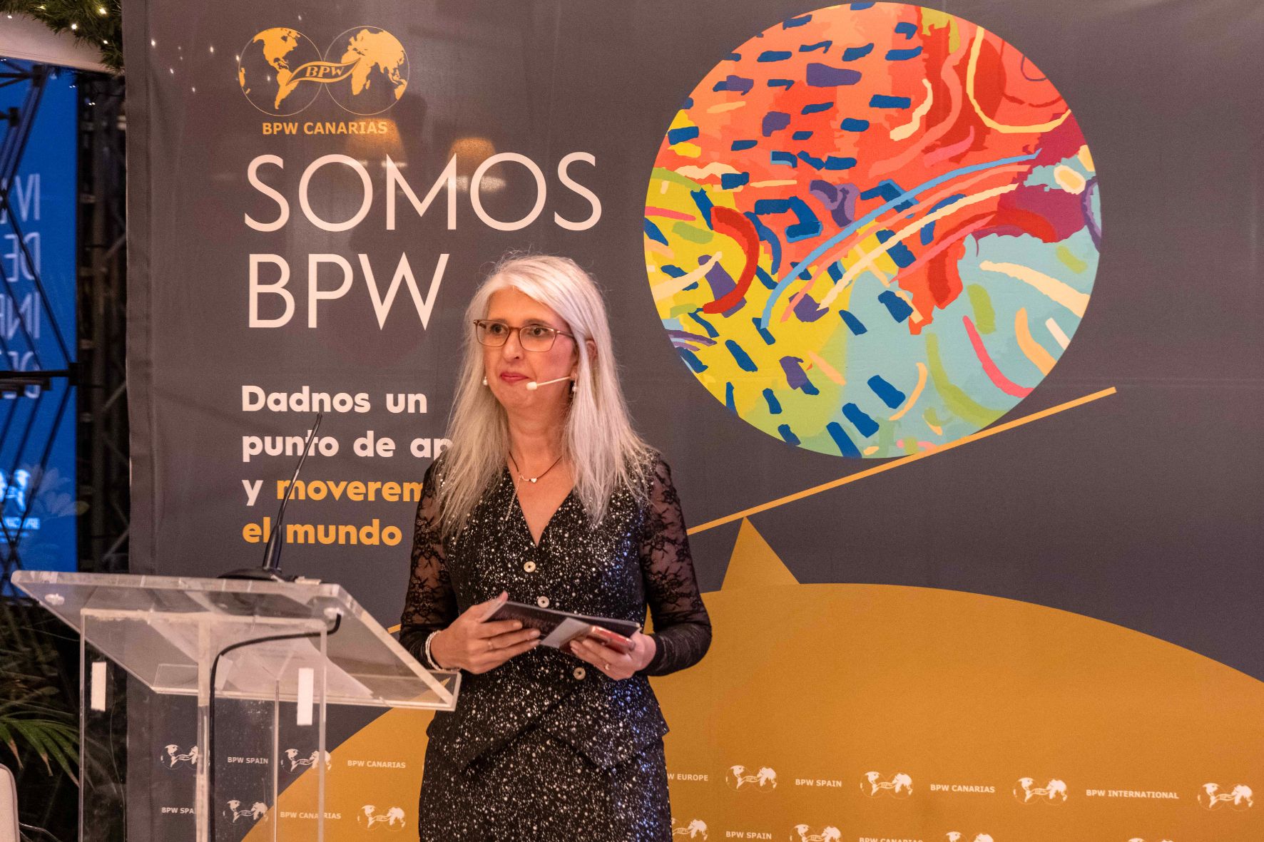 Mónica Radován en el escenario de un evento de BPW Canarias con el backdrop 'Somos BPW'